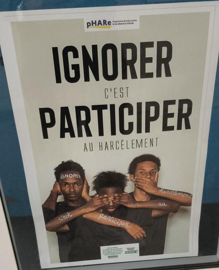 Affiche contre le harcèlement "ignorer c'est participer" avec trois personnes de couleur se couvrant yeux, oreilles et bouche.