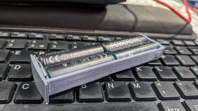 A pale blue plastic container holding 4 batteries.