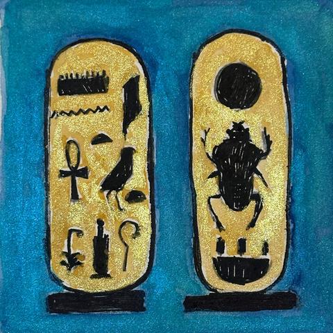 Sparkly teal blue background with gold sparkly cartouches outlined in black with black symbols in the middle. Left one spells out Tutankhamen with three symbols at bottom that signify being ruler of the north and south. Right one spells out Nebkhepherure.