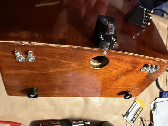 Photo of the backside of the hurdy gurdy showing strap mounts and string mounts.