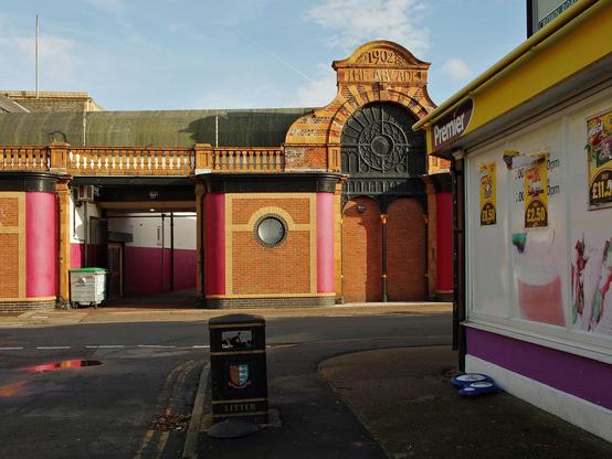 Back of Leisureland arcade with smart modern brickwork under some original 1902 features and the corner of a Premier, well, corner shop, nice sunshine and colours