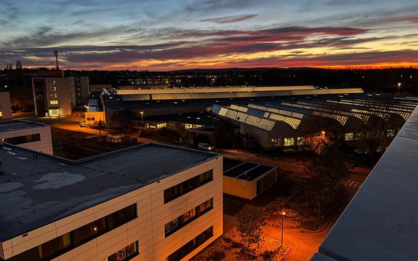 Blick auf ein Werksgelände von oben kurz vor dem Sonnenaufgang