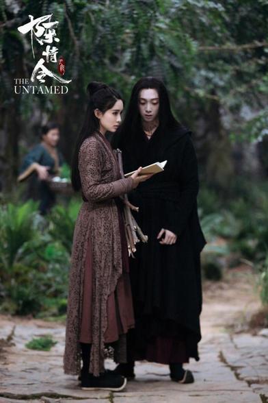 Wen Qing and Wen Ning stand on a path in the Burial Mounds, considering what to do for an invitation that was just received addressed to Wei Wuxian. In the background, another of the Wen remnants has been working on their radish farm.