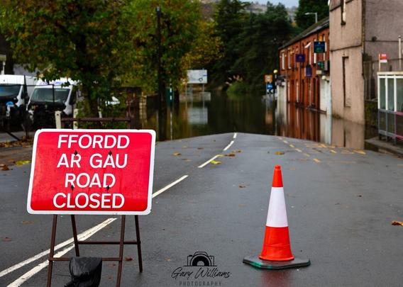 Road closed sign on Approach Road in Swansea with floodwater visible ahead at Cwmbwrla roundabout.