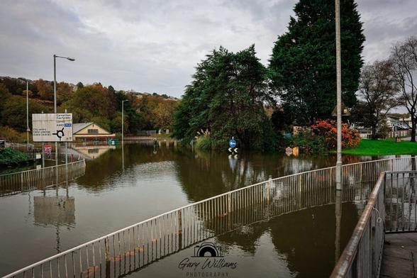 Flooded Cwmbwrla roundabout in Swansea seen from Carmarthen Road, with the junction entirely under water.