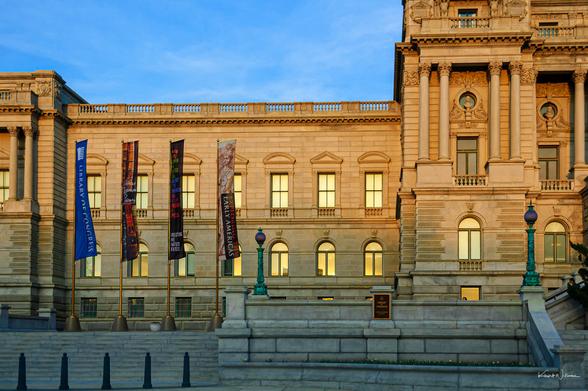 Library of Congress wing with banners and illuminated windows in evening light