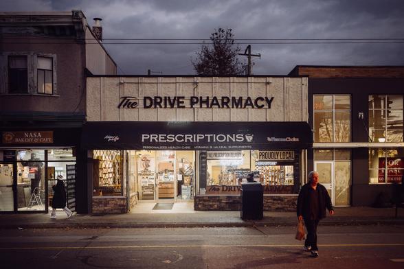 A pharmacy glows under twilight.