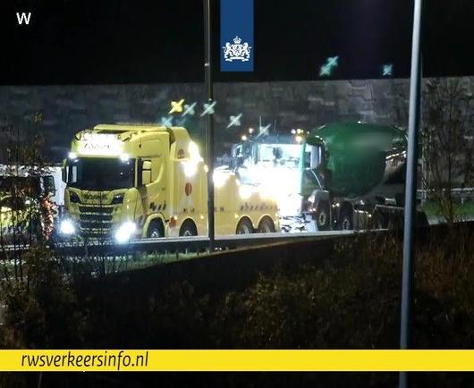 Een zware berger is bezig om de vrachtwagen, die betrokken is bij het ongeval op de A59 bij knooppunt Empel, op te takelen