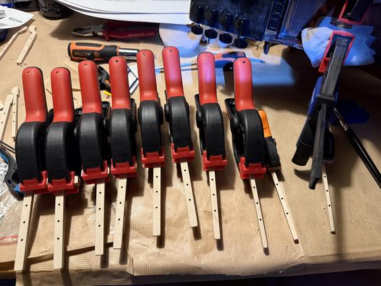 Photo of ten keys each with a glue clamps holding down on it.