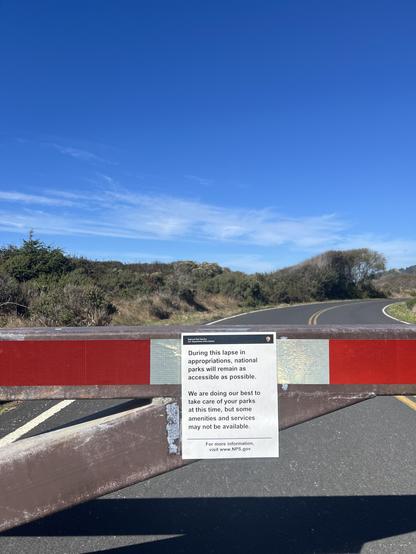 Redwood National and State Parks remain wonderful places to visit even during the current government shutdown. The NPS contingency plan provides detailed information regarding changes to visitor services, however, generally speaking, the roads and trails remain open, even as the visitor centers and associated parking areas are closed. This sign is from the access road to the Kuchel Visitor Center, which has been closed during the shutdown. That said, the surrounding areas are open and parking is available. Hope this helps you if you are planning a visit. (Sign on a red and white gate, with a road trailing off behind, all under a blue sky.)