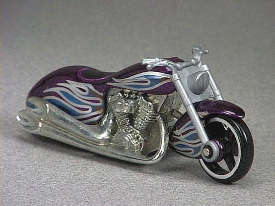 Released in 1997, Metal Flake Purple Scorchin' Scooter- #9 of 12 of 1997 First Editions with Mc3/Mcl wheels. Tampo: Silver/blue flames on front fender/gas tank/body. Packaging: Blister Card. Metal Body, Metal Base. Made in Malaysia. Scarcity: 1/10