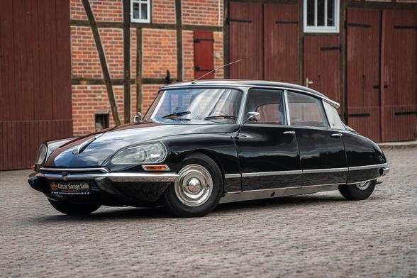 A photo of a shiny black Citroën DS showing a three-quarter view.