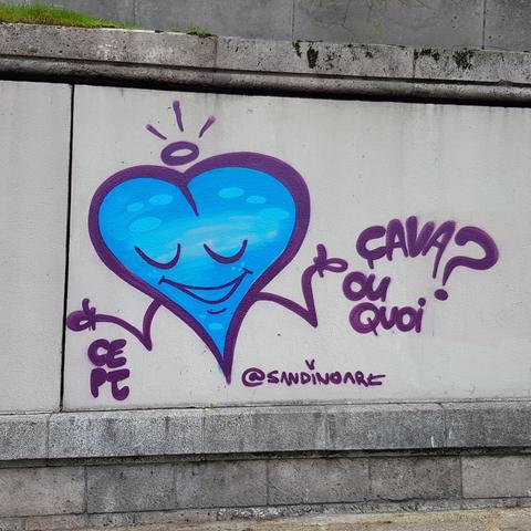 A mural of a big blue heart with a smiling face next to text "ça va ou quoi?"