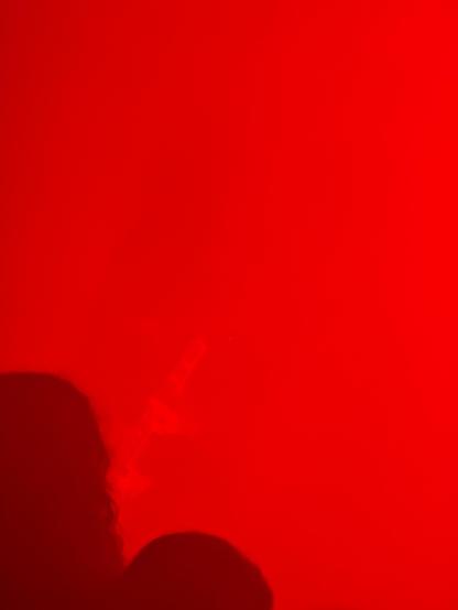 Red smoke and faint outline of a guitarist on stage