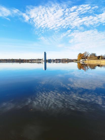 Blick auf den Wikingturm bei blauem Himmel und Spiegelungen in der Schlei