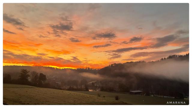 Spektakulärer Sonnenaufgang in Geb und Orange über den Feldern