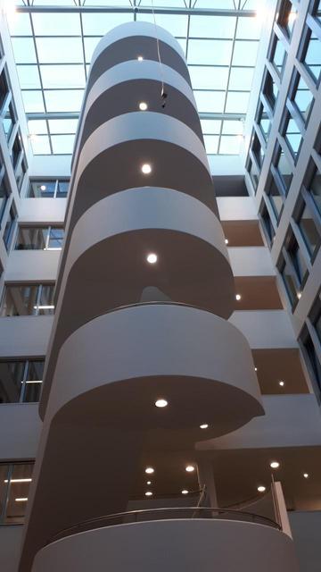 eine über 6 Etagen gehende steilisch verkleidete Treppe in einem Atrium.