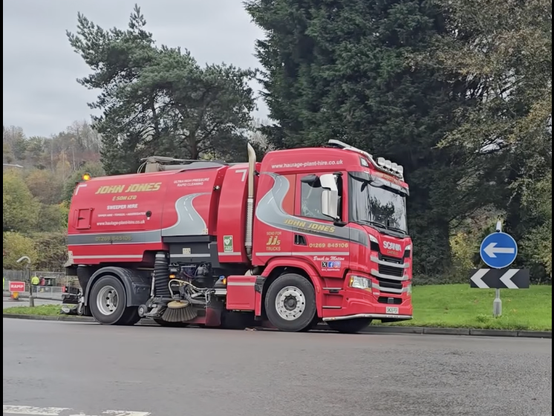 Road sweeper lorry cleaning Cwmbwrla roundabout following flooding.