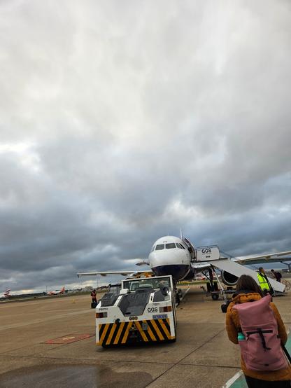 An image of a British Airways plane on the ground against a cloudy sky.