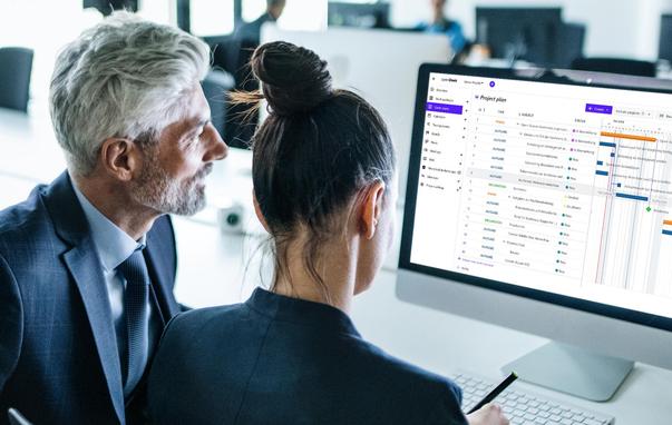 Two people collaborating in an office, looking at a laptop screen displaying the openDesk platform, symbolizing secure digital collaboration in government.