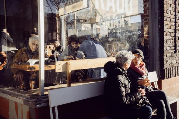 Patrons in a busy cafe window.