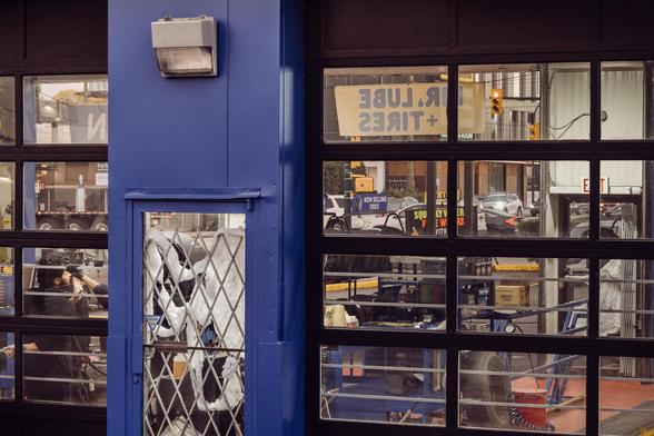 Employees pass the time at a quiet muffler shop.