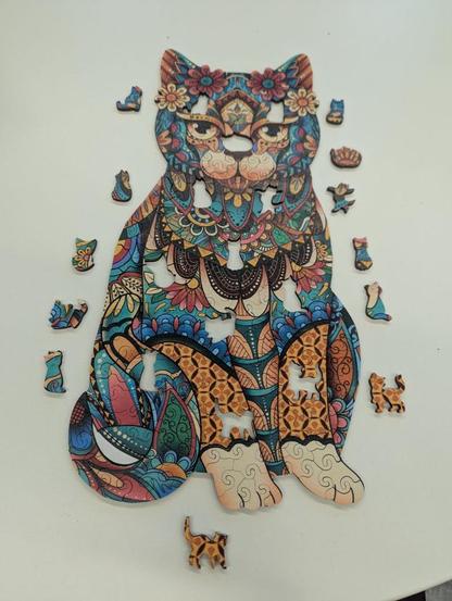 Photo of a colourful cat shaped puzzle with 12 tiny (single-piece sized) kittens taken out.