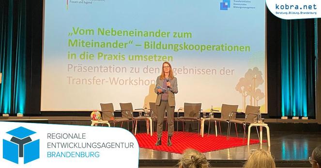 Die REAB-Brandenburg-Moderatorin präsentiert auf der Hauptbühne der Fachkonferenz in einem Stuhlkreis vor der Leinwand stehend die Ergebnisse ihres Workshops.