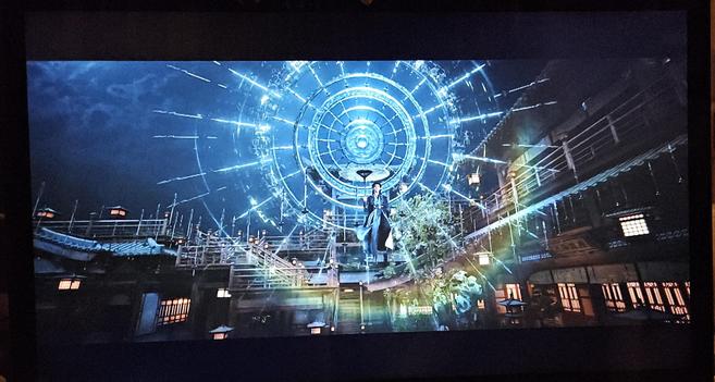 Su Mu mid air with his umbrella and his 18 blades formation. The latter is a tripple layer halo of swords and its light creates a rainbow glare at its bottom.