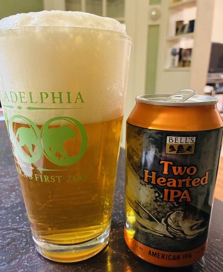 A pint glass of amber beer, topped with a thick layer of foam filling about a third of the glass