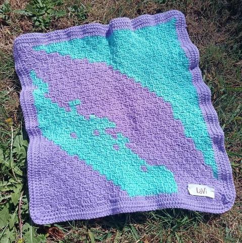 Quadrato Rorschach: ciascunə ci vede quel che vuole. Lilla e turchese con bordo lilla.