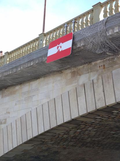 The sign is positioned on top of a stone bridge's arch.