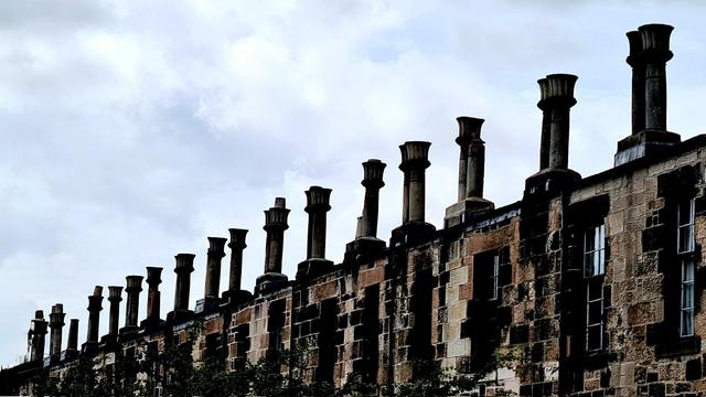 A row of tall Victorian chimneys with a shape based on that of a lotus flower.
