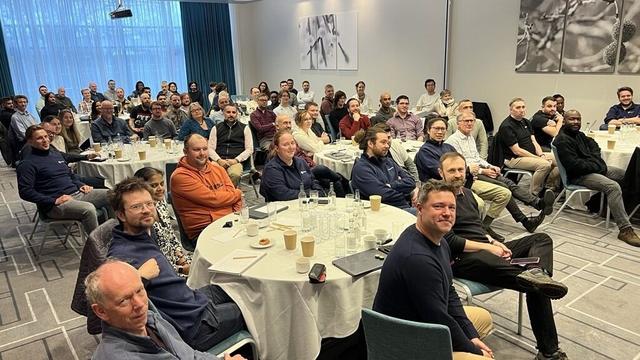 A group photo of many people sitting at tables