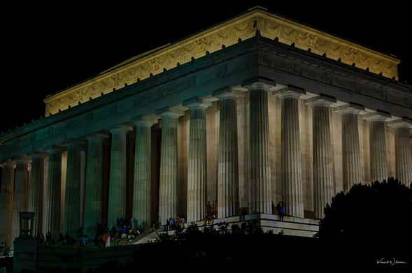 Lincoln Memorial illuminated at night with Doric colonnade and visitors on steps