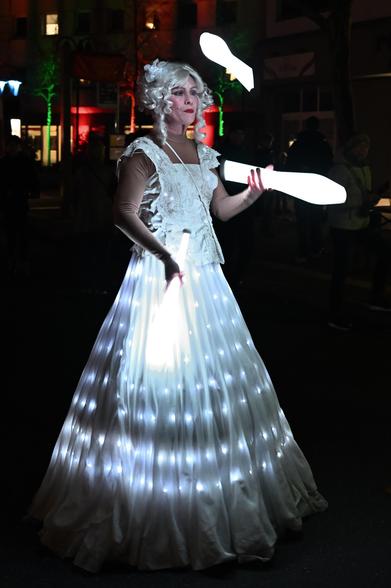 beleuchtete Jongleurin mit beleuchteten Jonglierkeulen