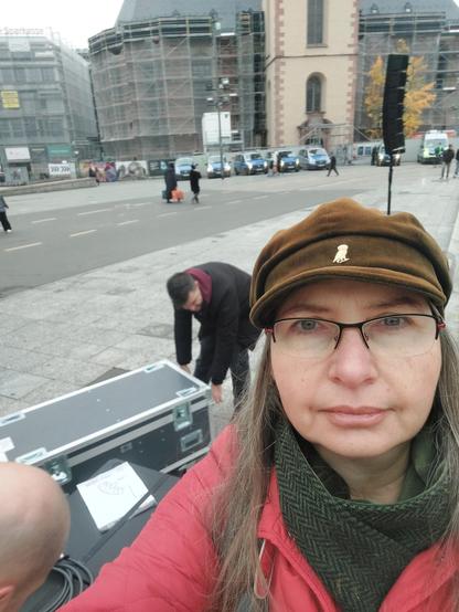 Selfie von mir, im Hintergrund schieben zwei Leute eine große Kiste. Weiter im Hintergrund die Katharinenkirche, davor viel Polizei