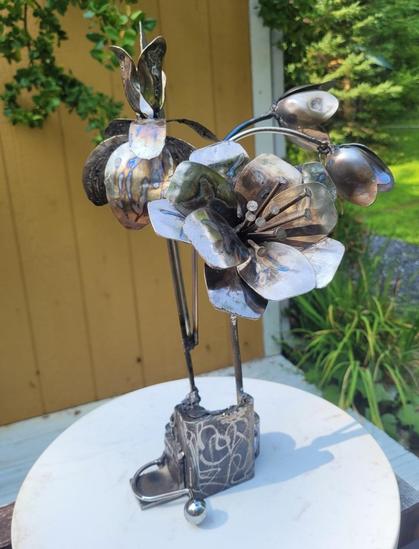 Fleurs bleues, dans la série bouquets improbables

Ceci est appelé du spoon art. Ce bouquet composé d'un iris des jardins  et de deux autres fleurs inventées est entièrement composé de rebut mais les fleurs sont aussi faites à partir de cuillères. L'une est sous forme de 3 clochettes et l'autre a les pétales grandes ouvertes l'une sur l'autre. Les fleurs ont été chauffées pour leur donner un aspect bleuté. 

100% rebut