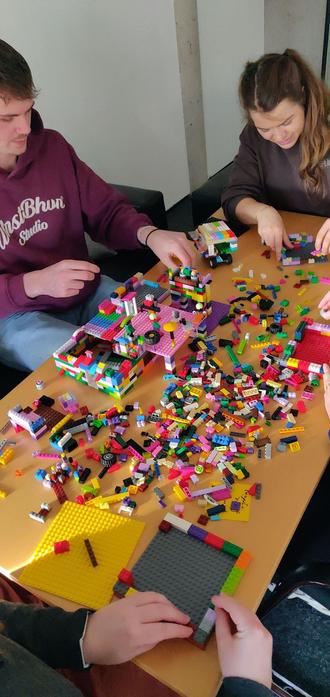 students around a table full of colorful danish building blocks