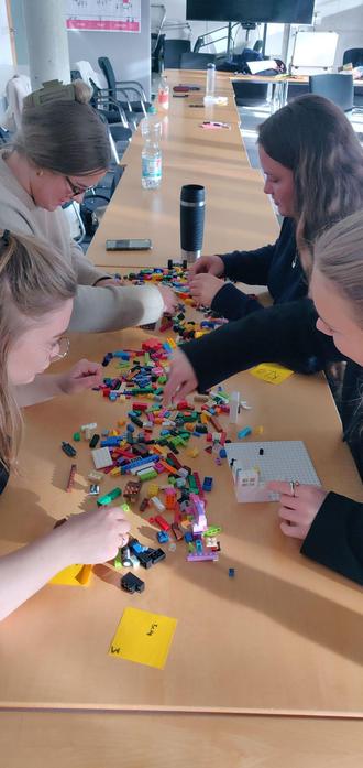 students around a table full of colorful danish building blocks