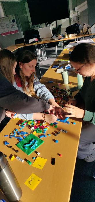 students around a table full of colorful danish building blocks