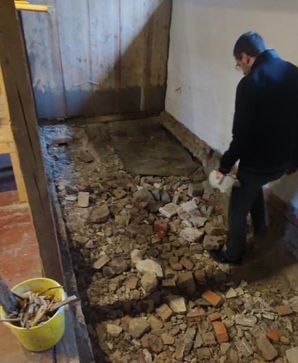 Der Untergrund unter dem entfernten Boden. Einer räumt auf.