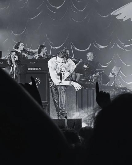 Yungblud im Oktober 2025 auf seinem Konzert in Düsseldorf auf der Bühne

Er beugt sich beim Singen nach vorne.