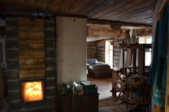 Intérieur de maison en bois, feu dans un poêle de masse.