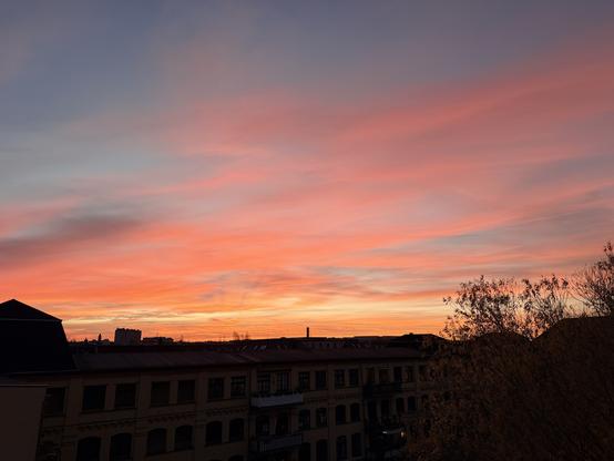 Sunrise over the east wing of the old factory complex that was converted to flats. The sky goes from a brilliant orange through all the pinks to a dusky blue.