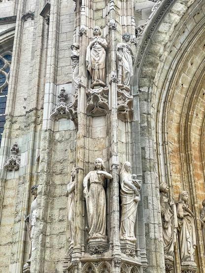 Exterior of Église Notre–Dame au Sablon in Brussels, seen from below—Gothic façade with statues.