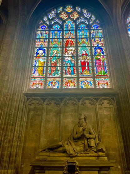 Interior view of the church with tall stained glass windows and golden altars, filling the space with colored light and quiet calm.