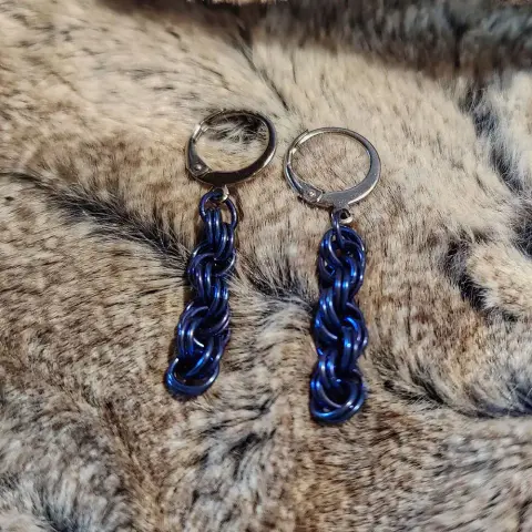 Boucles d'oreille en maille, dont le motif forme une sorte de spirale.