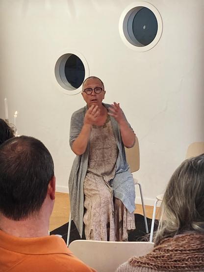 Apedibus contant sur une chaise devant un public