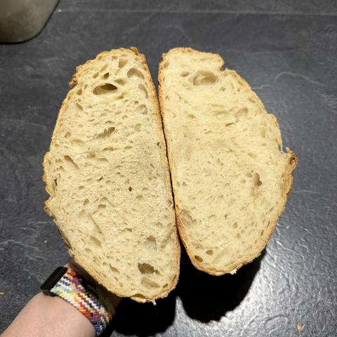 Ein halbiertes Weizenbrot mit knuspriger Kruste und luftiger, weicher Krume.